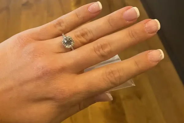 לקוחה מציגה טבעת הלו משובצת יהלום מרכזי עגול