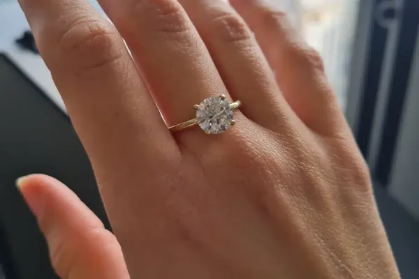 לקוחה מציגה טבעת סוליטר עם יהלום מרכזי עגול