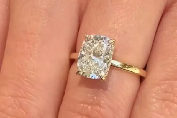 לקוחה מציגה טבעת סוליטר עם יהלום קושן